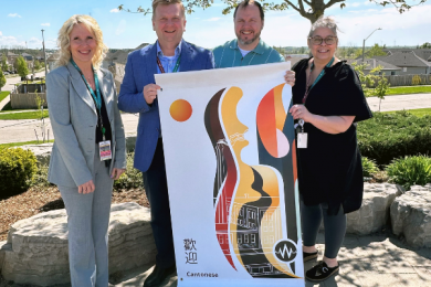 Picture of Senior Executives at the Hospital standing with Capital Projects and Past Equity, Diversity, Inclusion and Belonging Committee Chair, who worked on new welcome banners for the hospital parking lot. Welcome is in multiple languages.